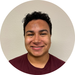 Close-up headshot of tutor Gabe standing in front of a white wall.